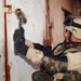 Spc. Kovach uses a sledgehammer to pound off the hinges
