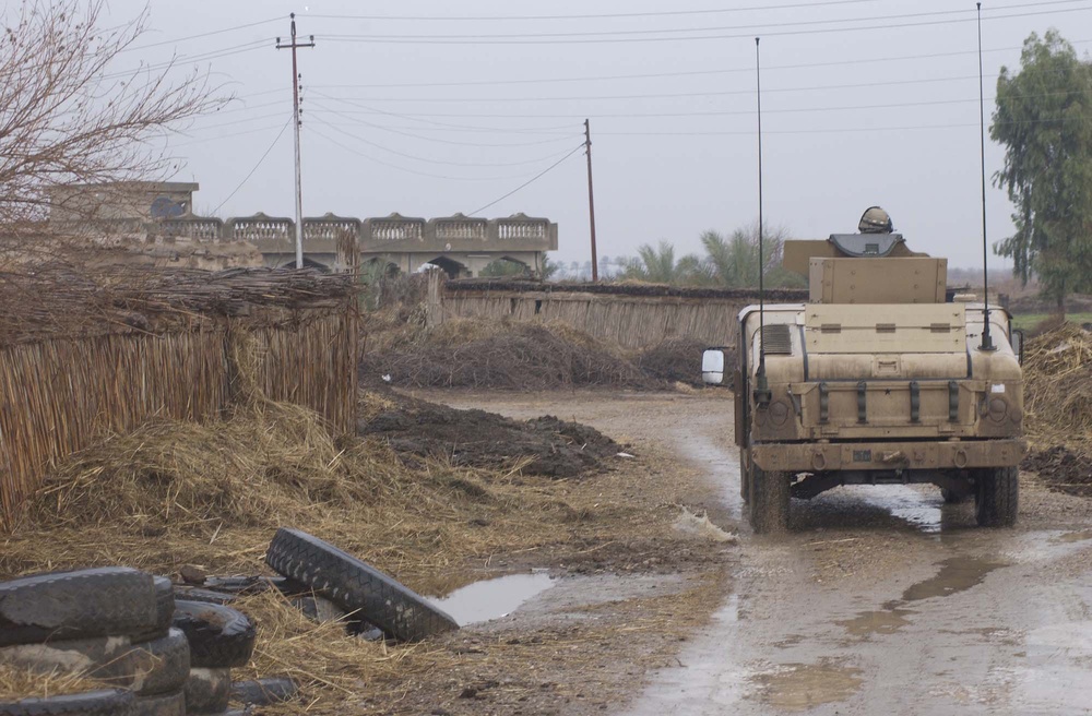 A U.S Army HUMVEE passes through an Iraqi village