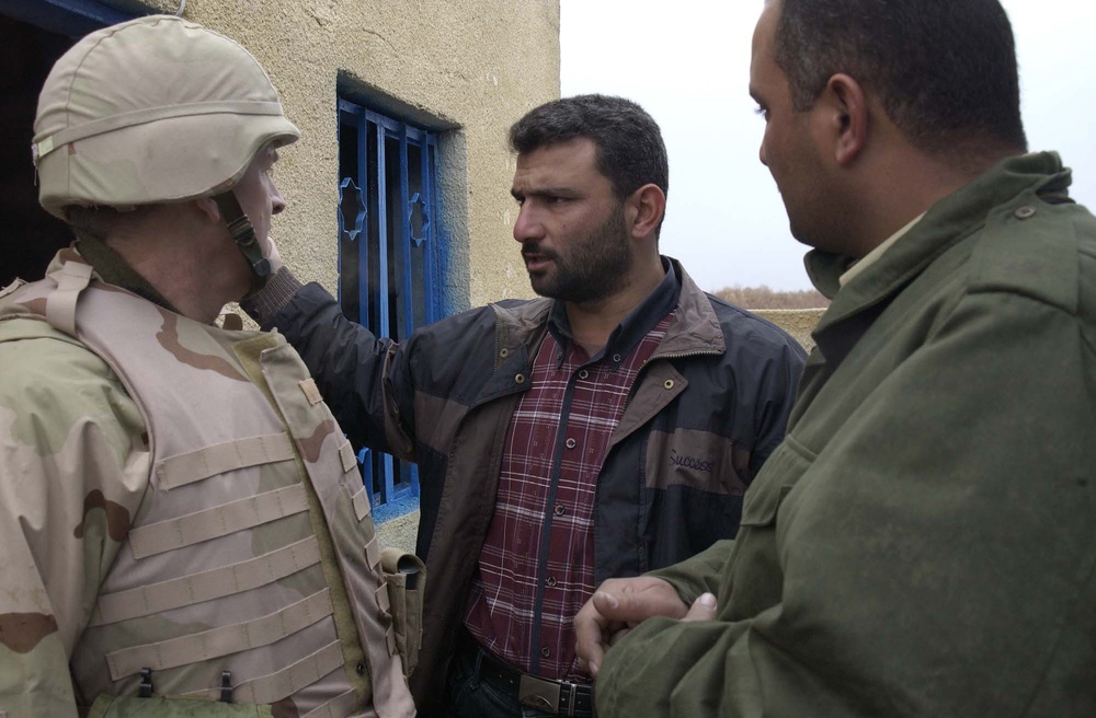 Lt Col Ronald Kirby discuss water issues with local Iraqis