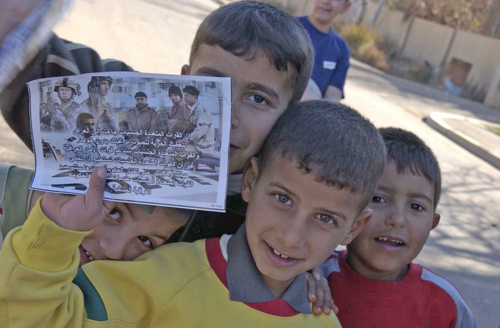 Young Iraqi boys hold a voting flyer