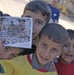 Young Iraqi boys hold a voting flyer