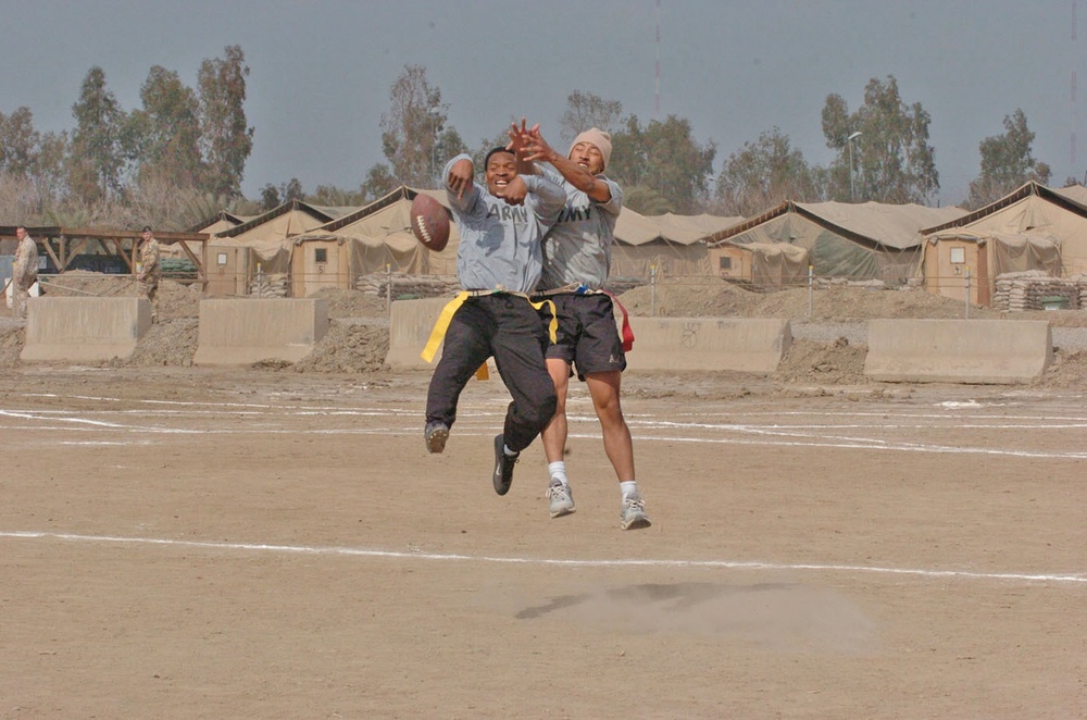 Two soldiers go up for the ball during flag football