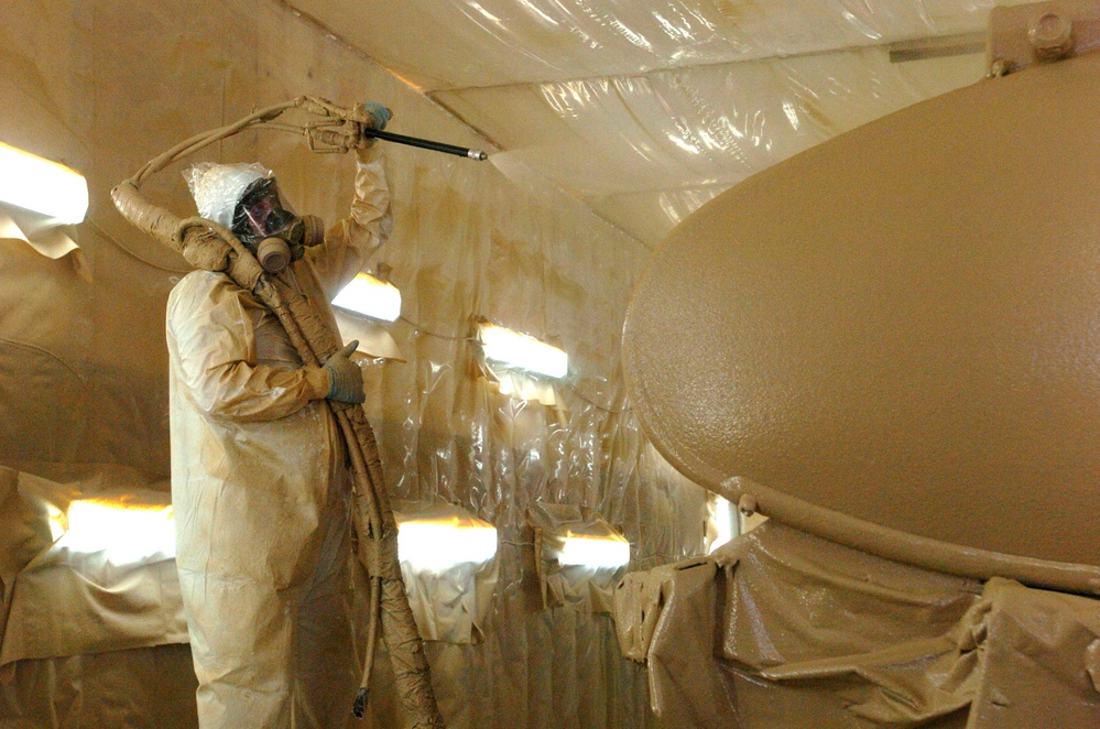 Andy Larson sprays protective polyurethane coating on an tanker
