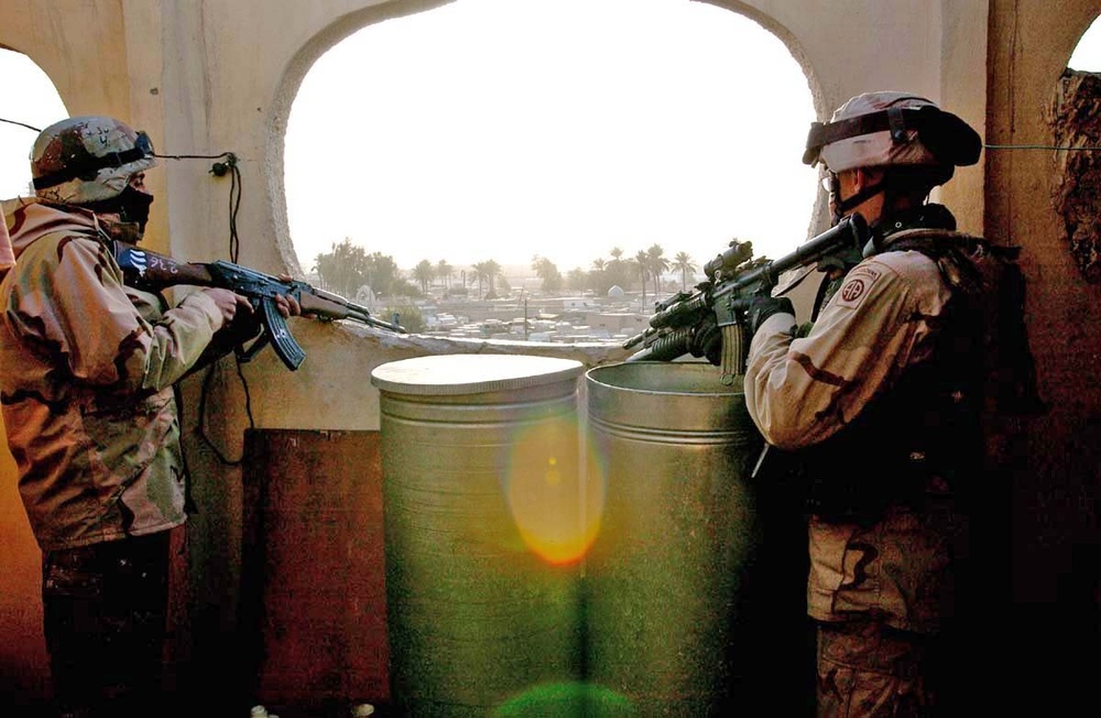 Pfc. Malcolm Ackers and his counterpart watch a street