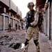 A paratrooper moves down a narrow alleyway