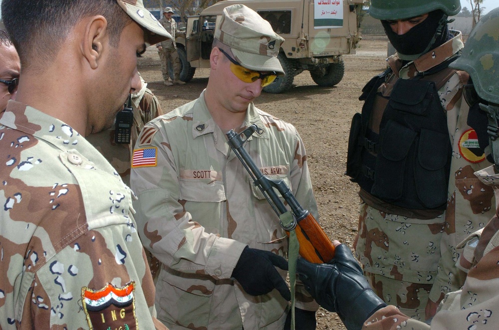 Staff Sgt. Mark Scott Inspects an Iraqi Army Soldier Rifle