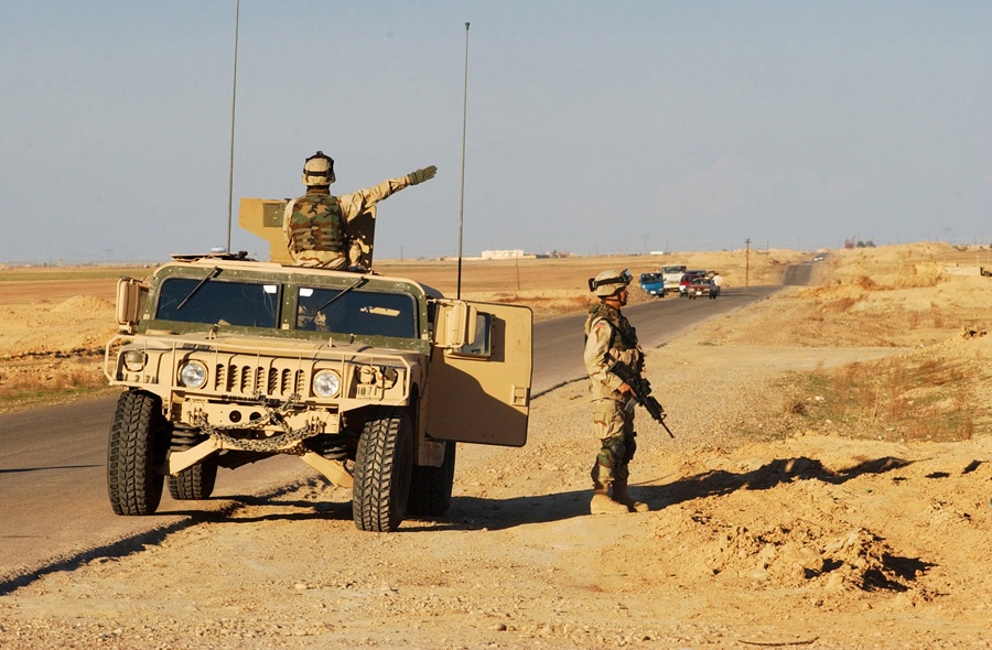 Cavalry Scouts signal local traffic to stop during patrol