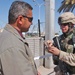 Pfc. John Debrock examines the ID card of an Iraqi man