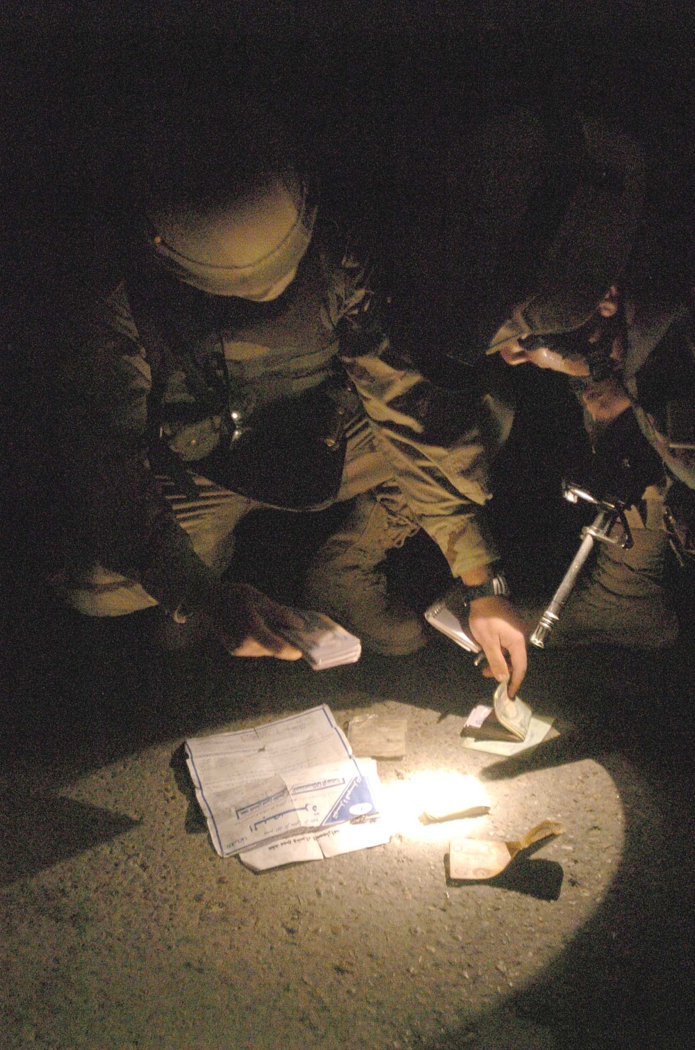 Soldiers inspect documents and money founded