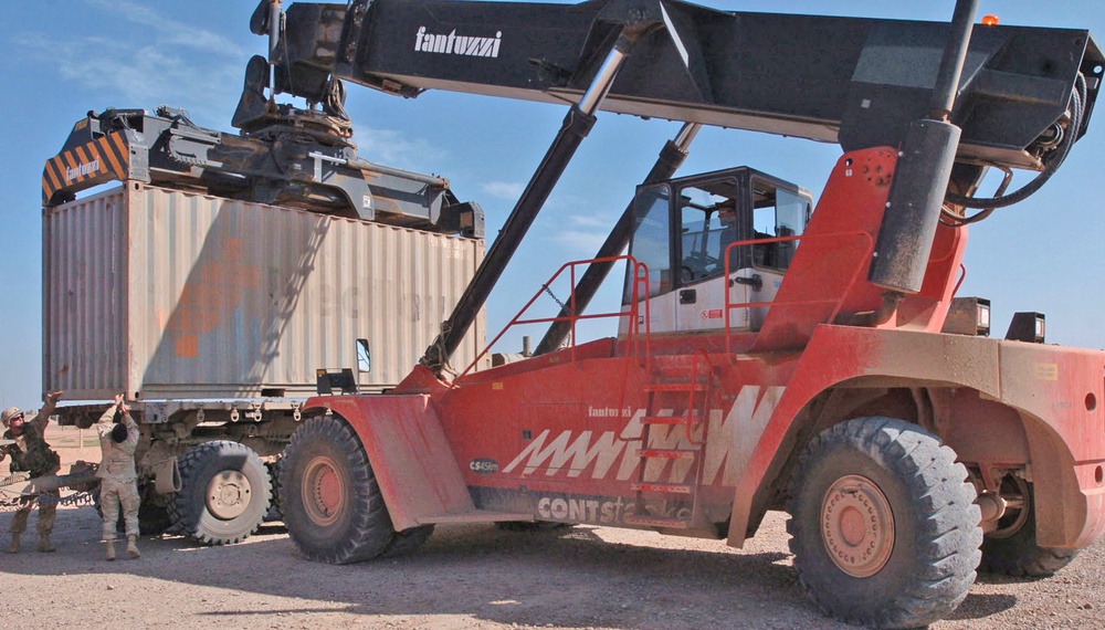Workers Unlatch a Shipping Container So It Can Be Taken Off