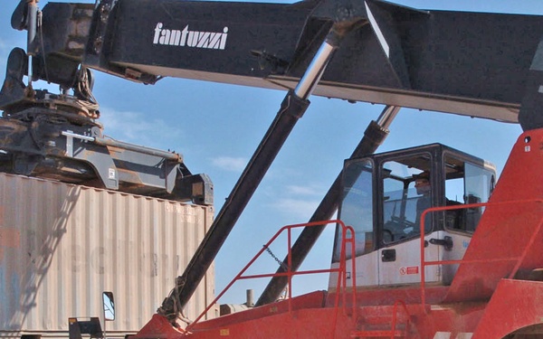 Workers Unlatch a Shipping Container So It Can Be Taken Off