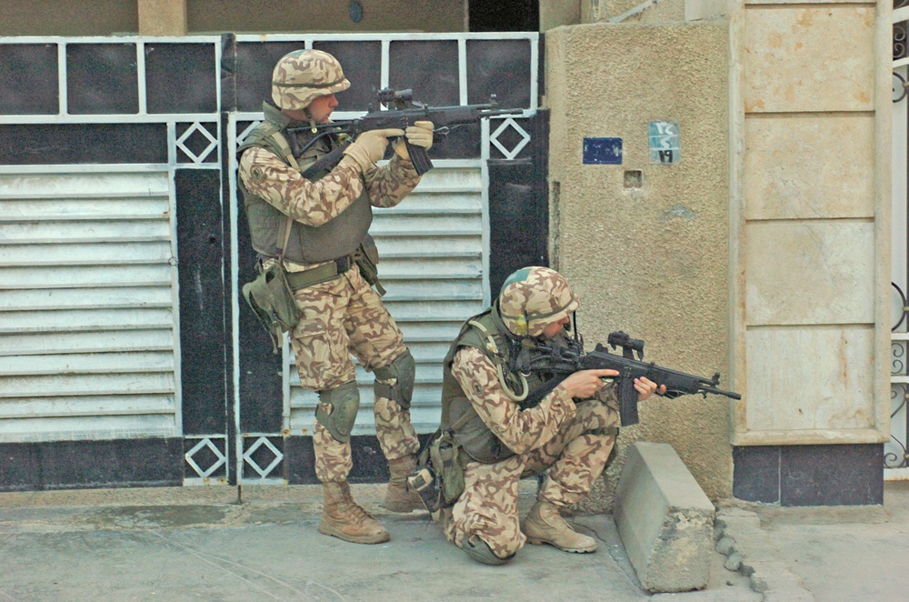 Estonian Defense Forces take aim while patroling a street