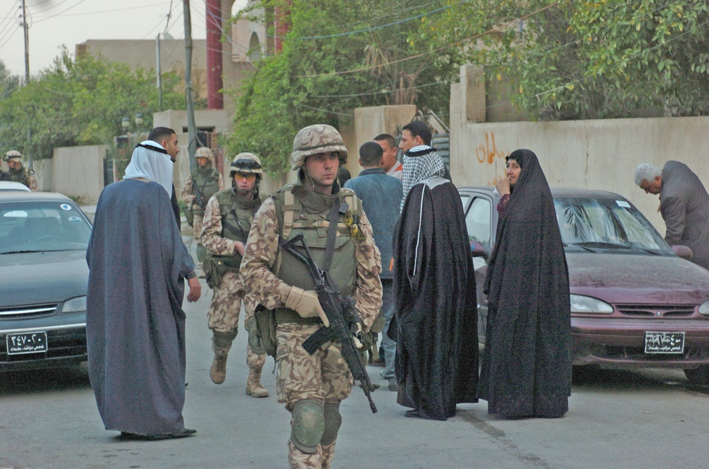 Estonian soldiers walk past an Iraqi wedding party