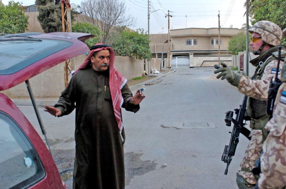 Estonian Cpl. Ranno Pettai searches an Iraqi citizen car