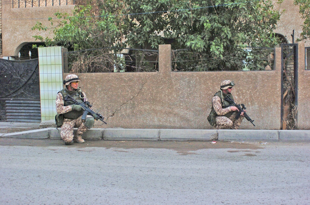 Estonian soldiers await orders to begin patrolling the street