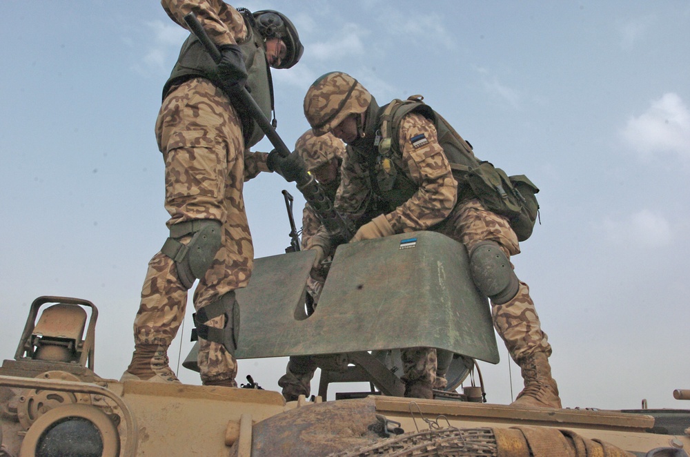 Estonian soldiers mount a .50-caliber machine gun on the turret