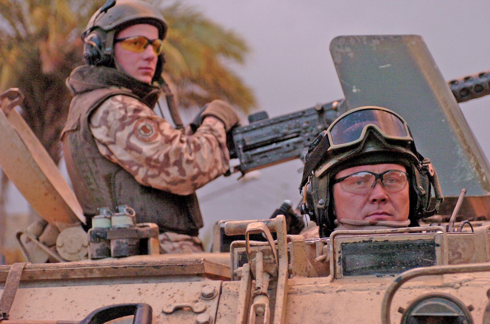 Estonian soldiers stand guard in an armored personnel carrier