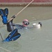 Sgt. Roberts holds the guide pipe while two divers secure it