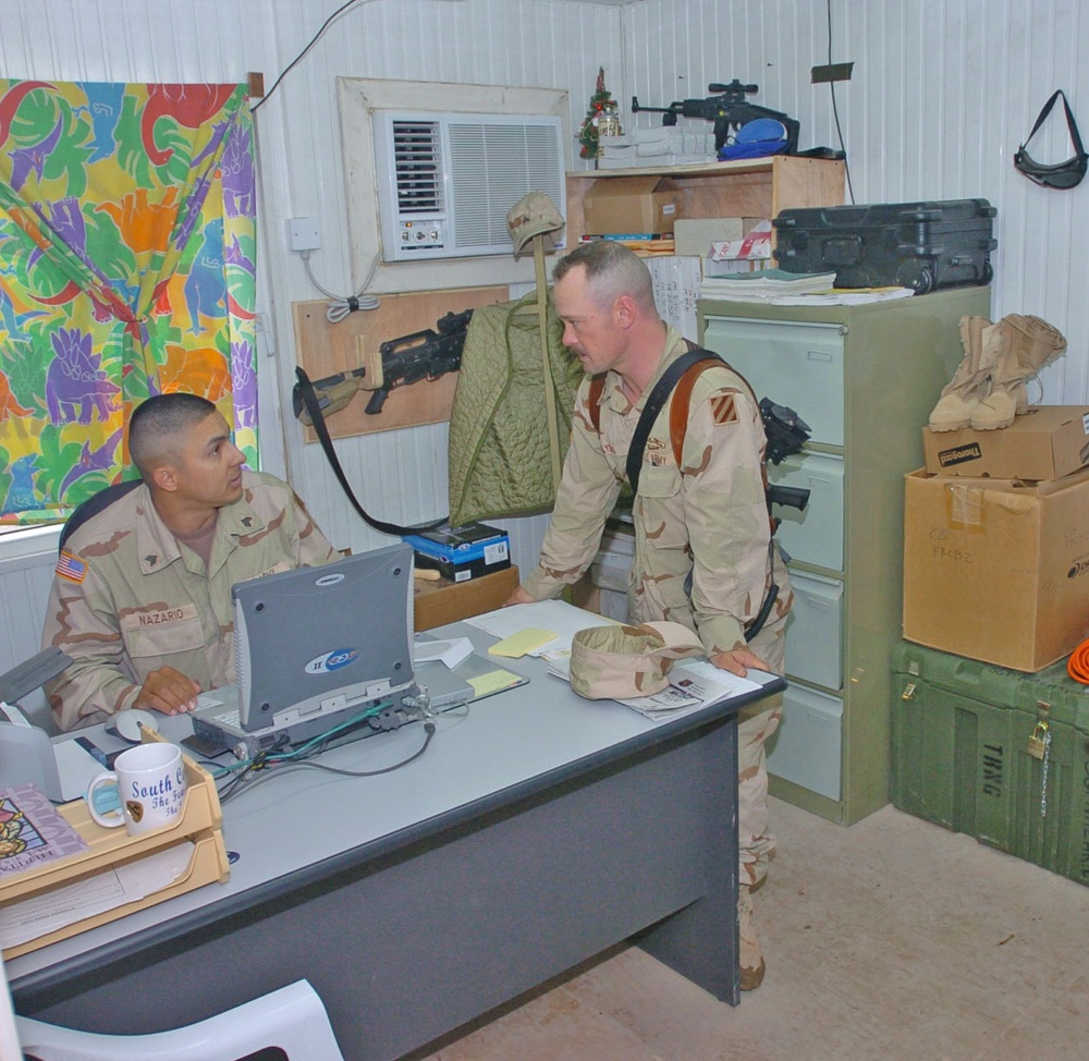 Soldiers discuss an upcoming range in the company training room