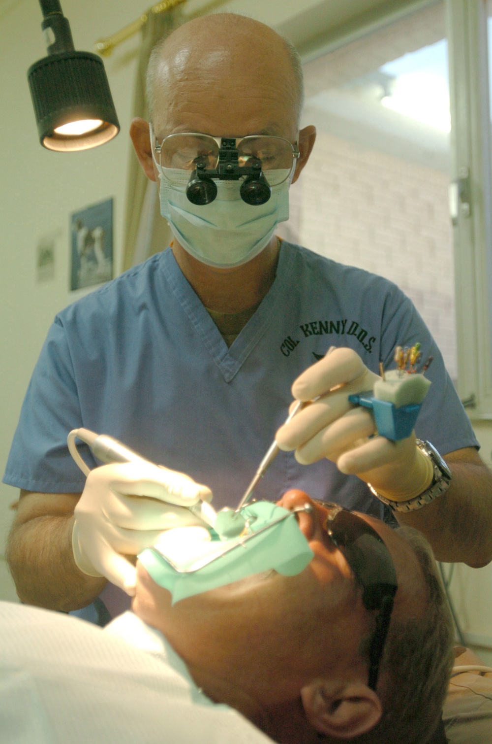 Col. Kraig Kenny performs oral surgery on Maj. McPherson