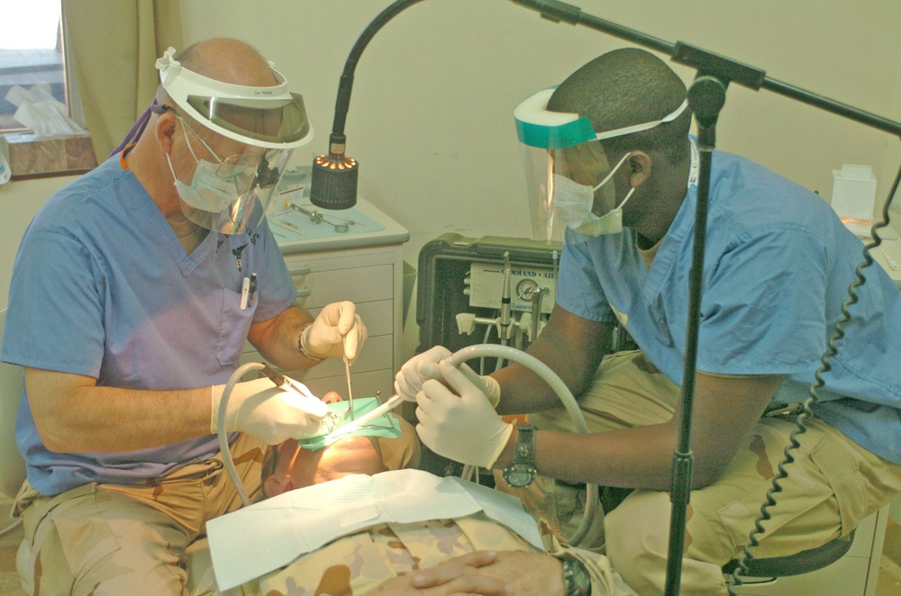Col. Kenny perform oral surgery on Maj. John McPherson