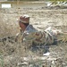 An Iraqi Army Soldier low crawls through the brush