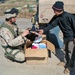 Spc. Jeff Sinclair Hands a Teddy Bear to an Iraqi Child