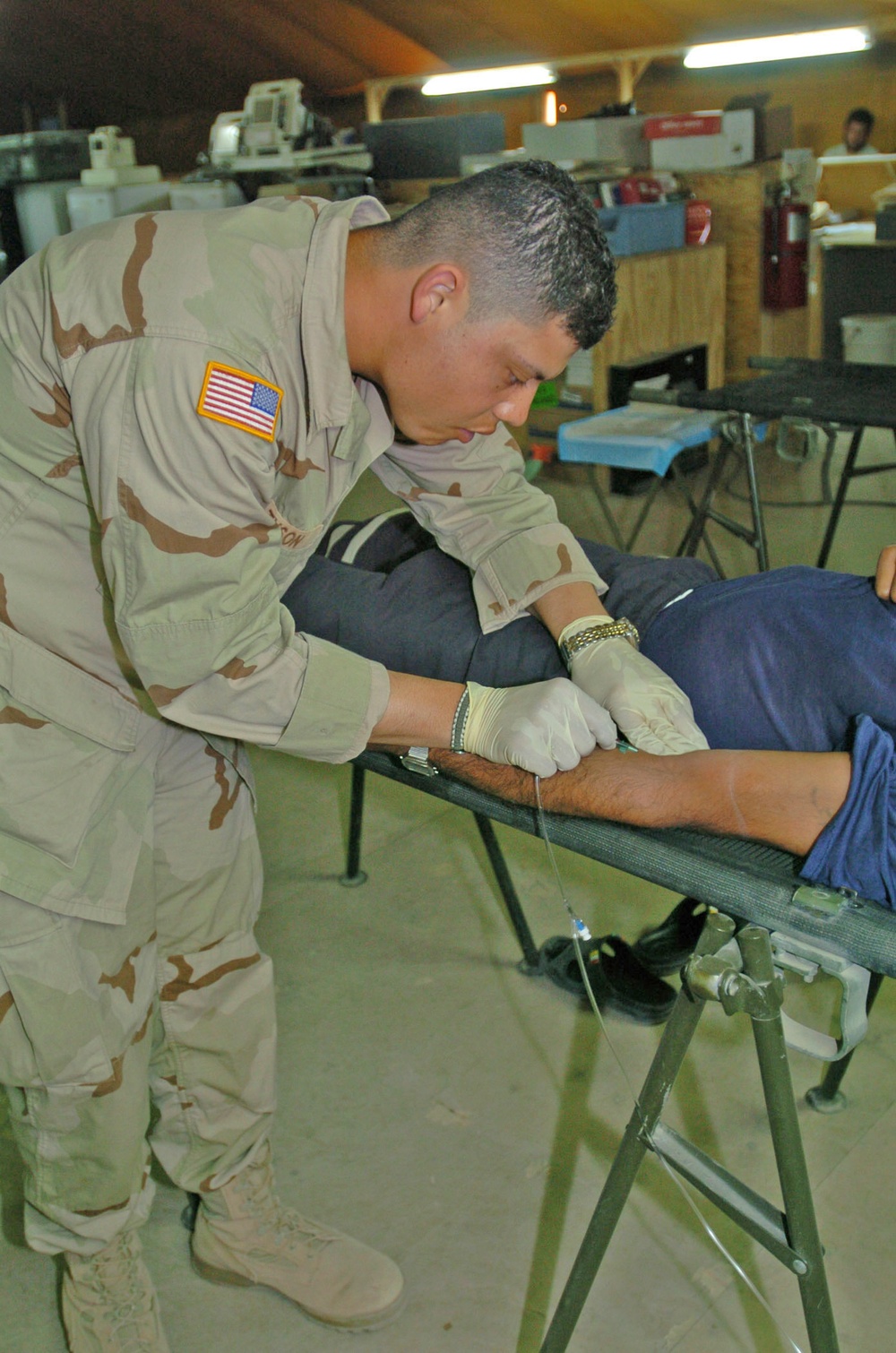 Pvt. Tyson rehydrates a Camp Bucca Internment Facility detainee