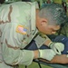 Pvt. Tyson rehydrates a Camp Bucca Internment Facility detainee