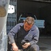 A Iraqi mechanic works on a gas tank