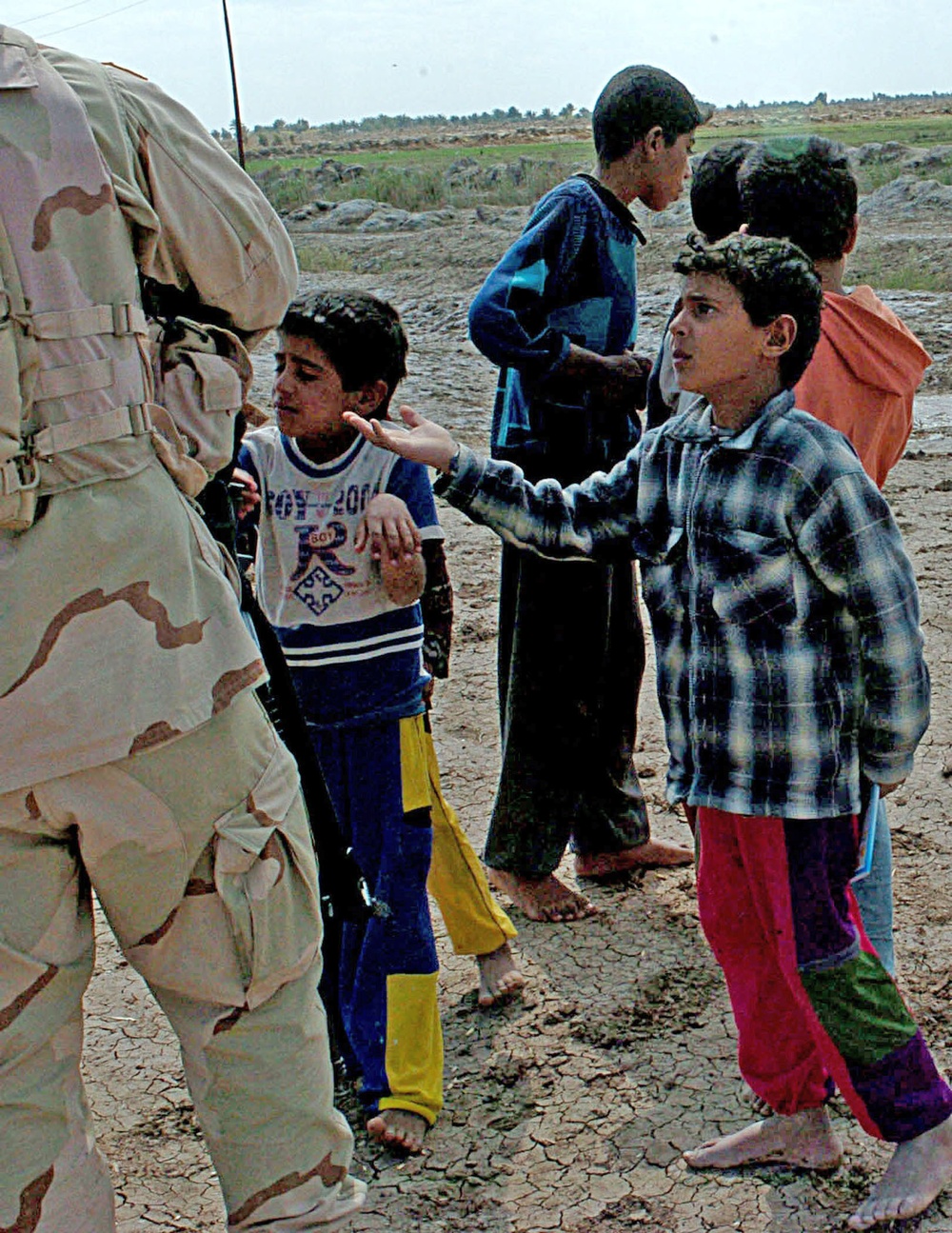 Iraqi children beg Staff Sgt. Stevie Knox for pencils