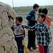 Iraqi children beg Staff Sgt. Stevie Knox for pencils