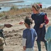 Staff Sgt. Stevie Knox hands out pencils to Iraqi children