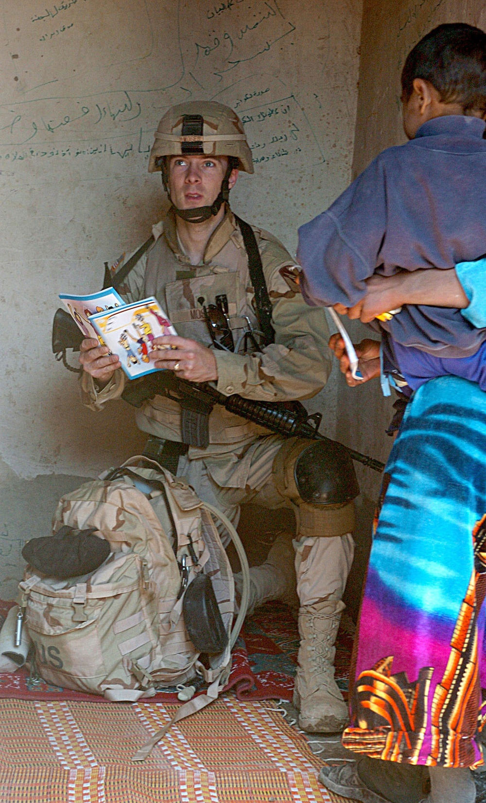 Spc. Troy Moses gives coloring books and pencils