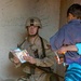 Spc. Troy Moses gives coloring books and pencils