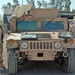 Two soldiers stand beside their recently repaired Humvee