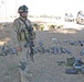 SFC Ware stands in front of a captured weapons cache