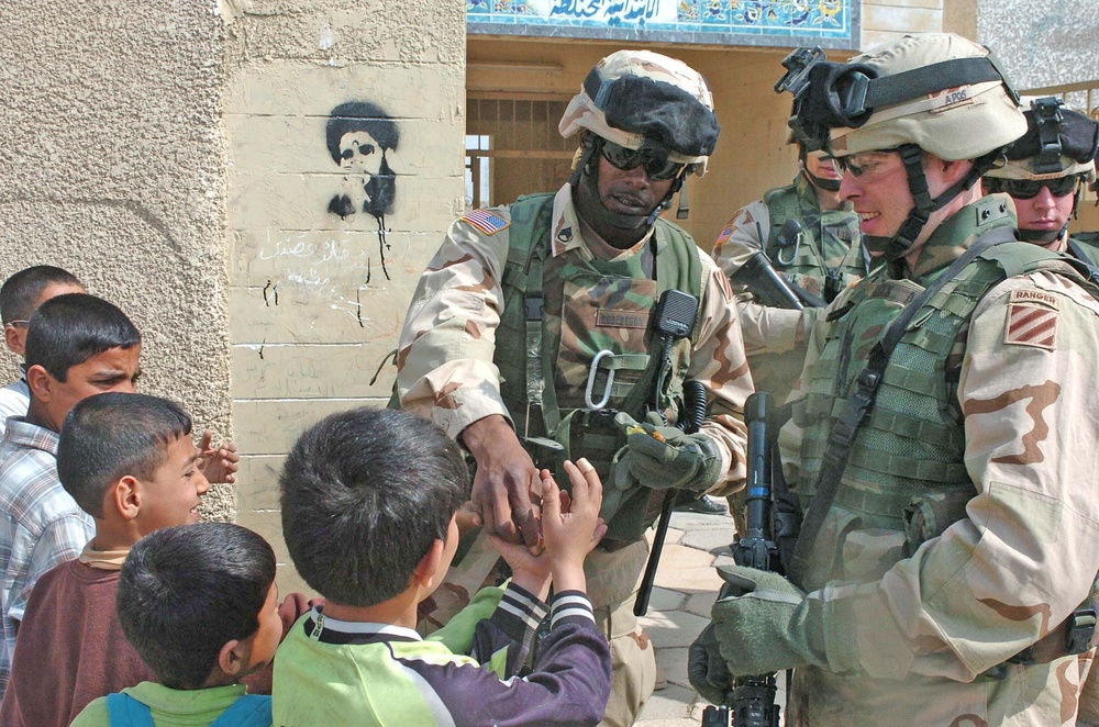 Soldiers hand out hard candy to kids in Sadr City