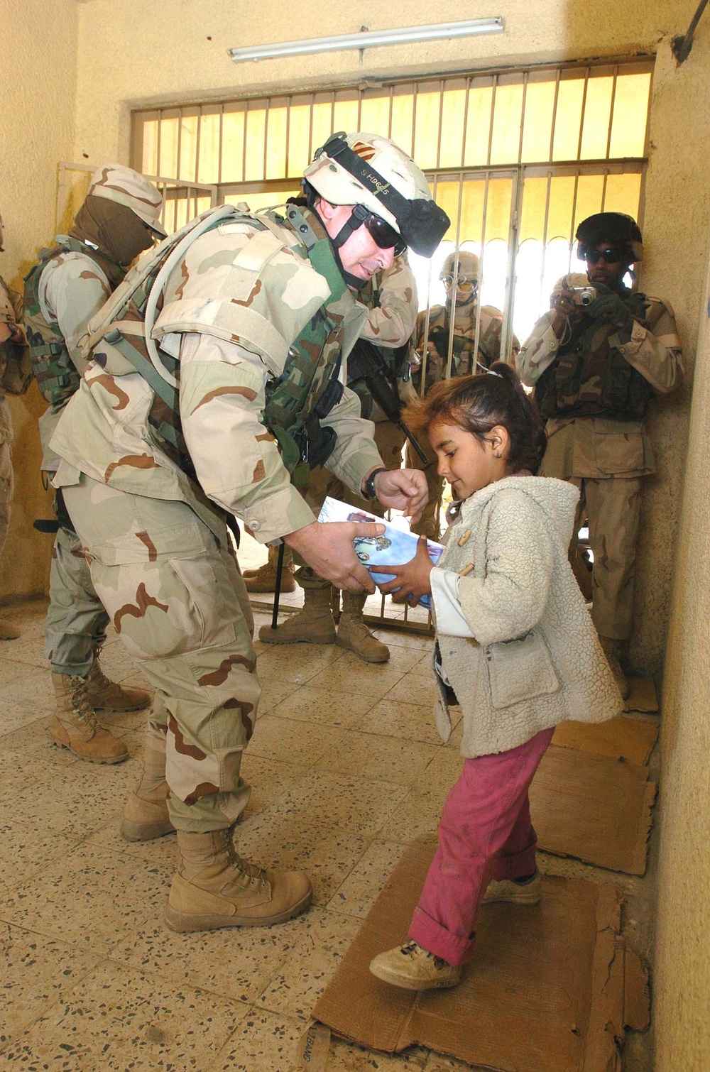 Chaplain hands a pair of sneakers and a coloring book
