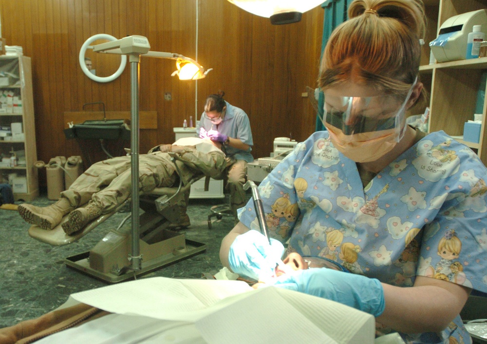 Pfc. Chasity Bowling cleans a patients teeth