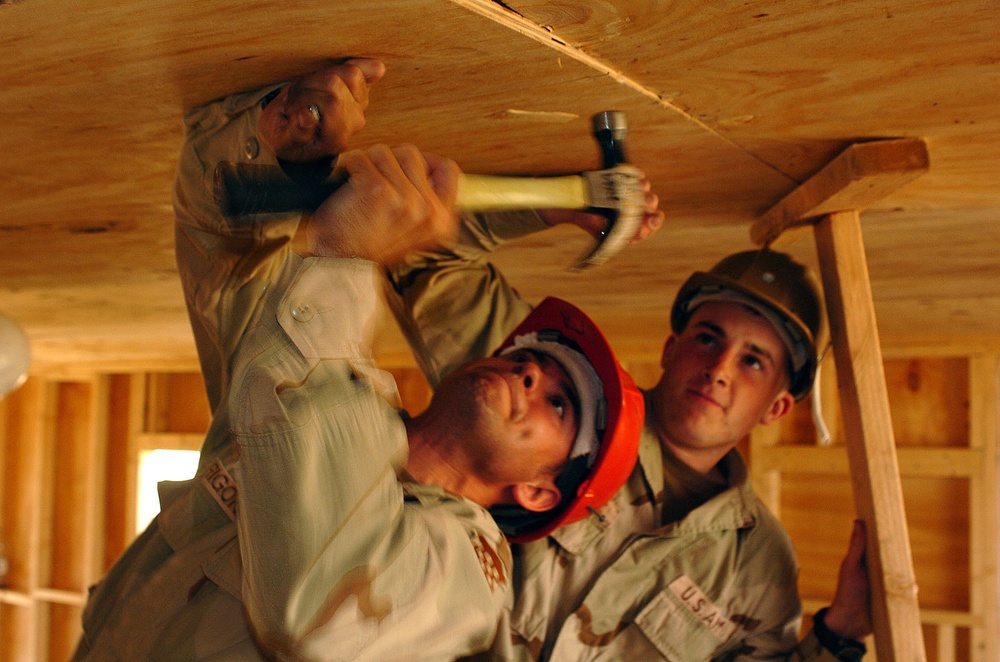SSgt. Arrigoni and Spc. Doncour nail the ceiling into place