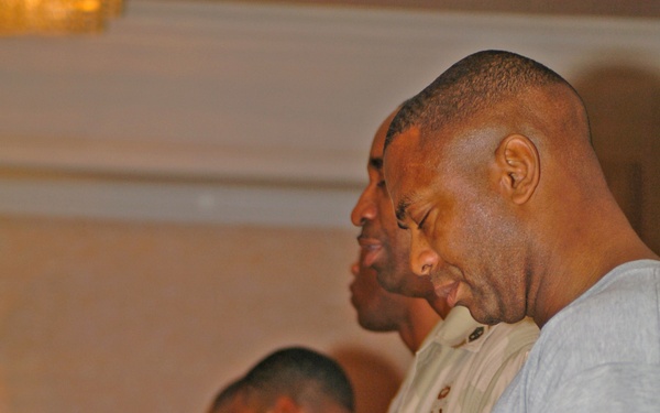 Members of the Camp Victory, Iraq, gospel choir pray