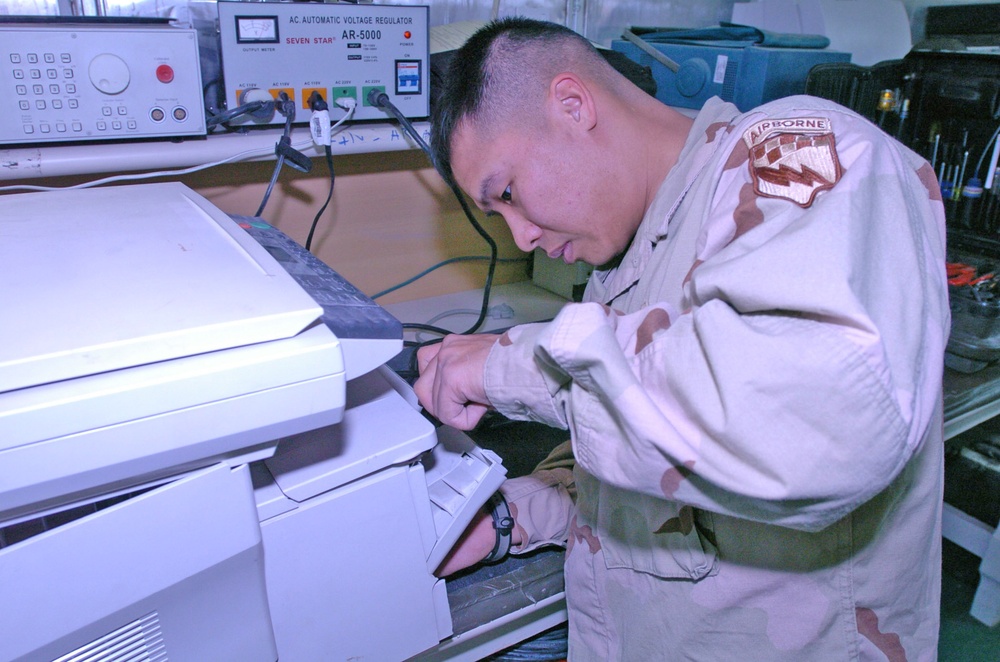 Staff Sgt. Roddy S. Nguyen repairs a copy machine