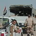 An Iraqi man pulls guard out of the back of a truck