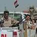 An Iraqi man pulls guard out of the back of a truck