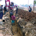 Local workers dig a trench for a sewer line
