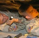 Two soldiers begin replacing the gearbox of an armored humvee
