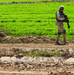 Staff Sgt. Rick Haerter examines an artillery round found