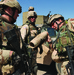 Two soldiers examine an artillery round founded