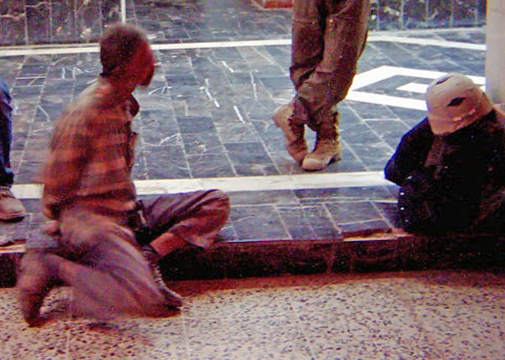 The insurgent talks to local police while awaiting transportatio